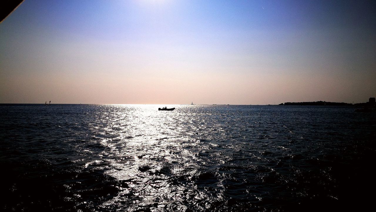 SILHOUETTE BOAT SAILING IN SEA AGAINST CLEAR SKY