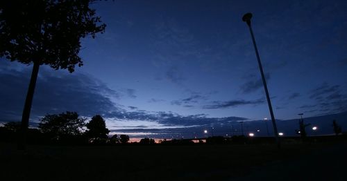 Silhouette trees against blue sky