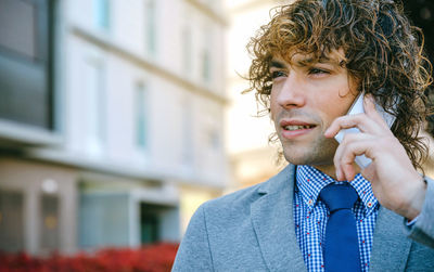 Portrait of young man looking away in city