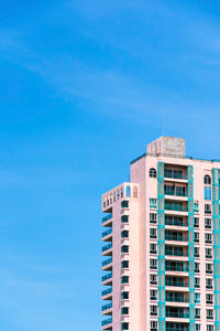 Low angle view of skyscraper against blue sky