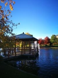 Built structure by trees against blue sky