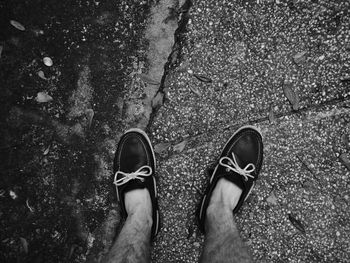 Low section of man standing on wet street