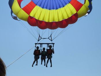 Low angle view of hot air balloons against clear blue sky