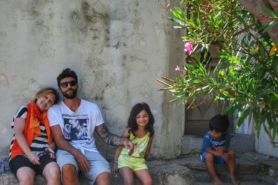 Happy family sitting outside old house