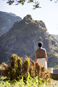 Rear view of man looking at mountain against sky