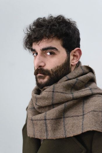 CLOSE-UP PORTRAIT OF MAN AGAINST GRAY BACKGROUND
