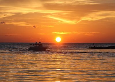 Boat sailing in sea at sunset