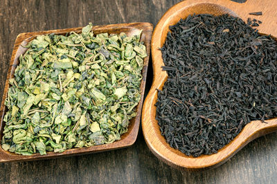 Close-up of dry herbal tea leaves in wooden bowls on table