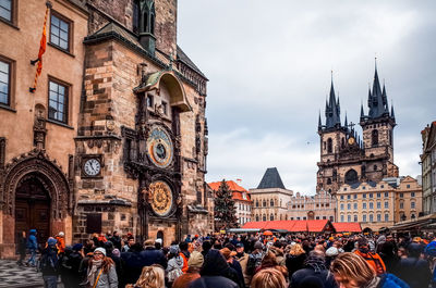 View of crowd in the city against cloudy sky