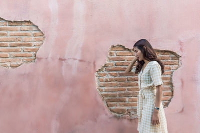 Woman standing against wall