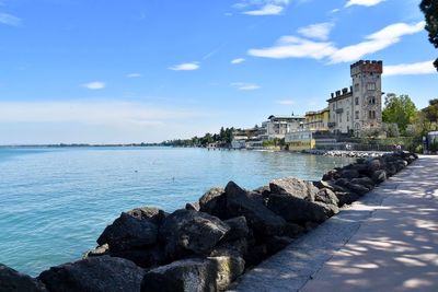 Scenic view of lake by buildings against sky