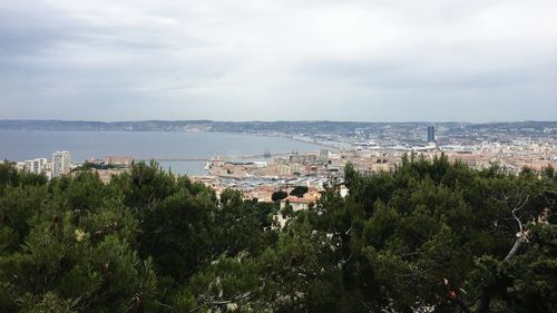 High angle view of townscape by sea against sky