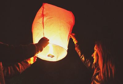 Close-up of holding hands over black background