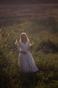 Rear view of woman standing on field