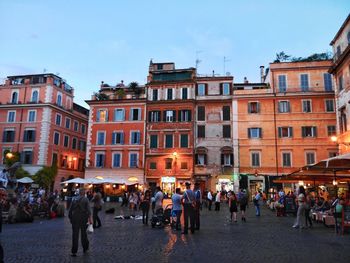 Group of people walking in front of buildings