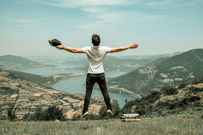 Full length of man standing on mountain against sky