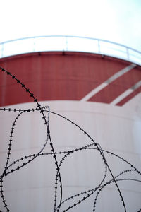 Barbed wire in front of industrial silo