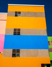 Low angle view of yellow building against sky