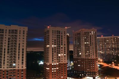 Illuminated buildings in city against sky at night