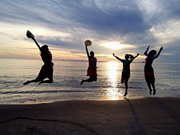 Silhouette of people enjoying at beach