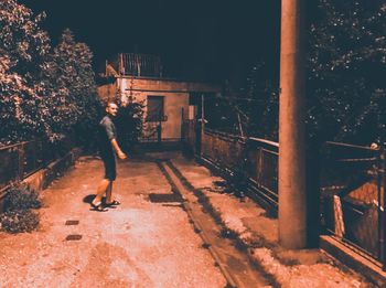 Man standing on footpath at night