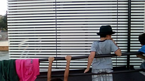 Children at railing in front of patterned wall