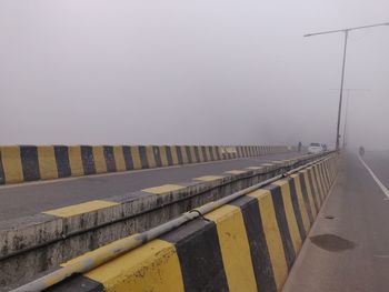 Road by bridge against sky