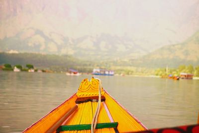 Cropped image of boat on lake against mountain