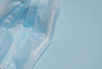 Close-up of wet glass against blue sky