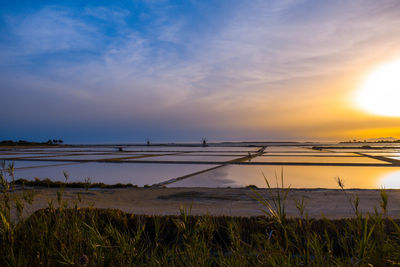 Scenic view of saline against sky during sunset