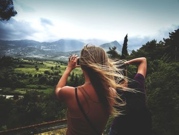 Women standing on mountain against sky