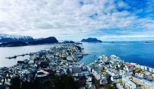 High angle view of city by sea against sky