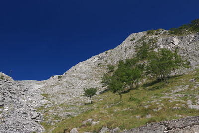 Low angle view of mountain against blue sky