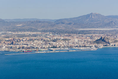 Aerial view of sea and cityscape against sky