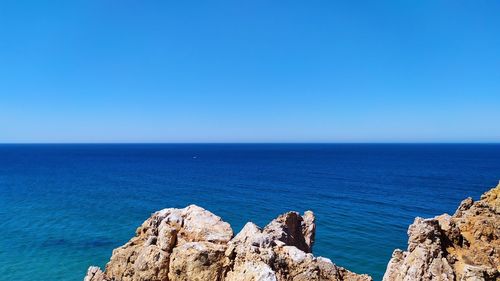 Scenic view of sea against clear blue sky