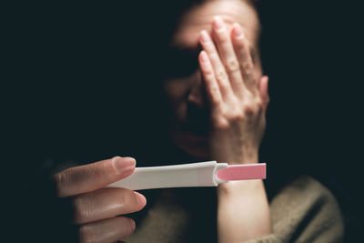 A woman sees a positive pregnancy test result and feels fear