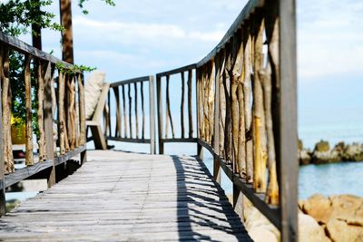 Footbridge over sea against sky