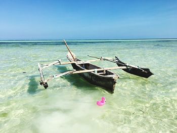 Boat on sea shore against sky