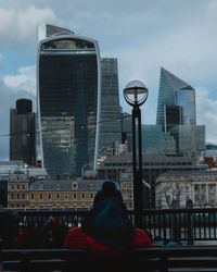 Rear view of man and woman against buildings in city