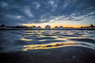 Surface level of beach against sky during sunset