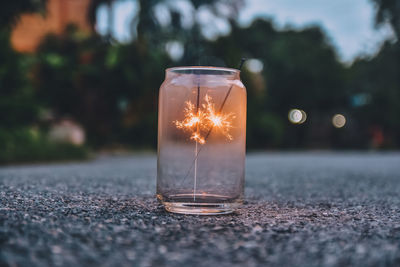 Close-up of sparklers burning in jar on road