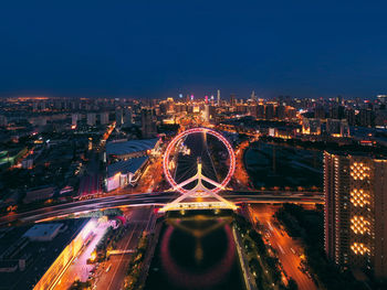 High angle view of illuminated bridge and buildings against sky at night