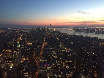 Aerial view of city lit up at sunset