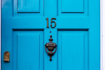 House number 15 on a blue wooden front door in london 