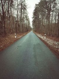 Empty road amidst trees in forest