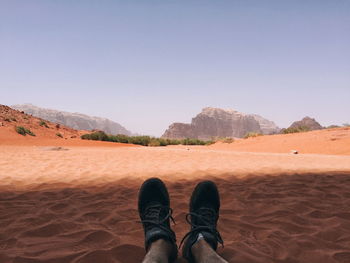 Low section of man on sand dune