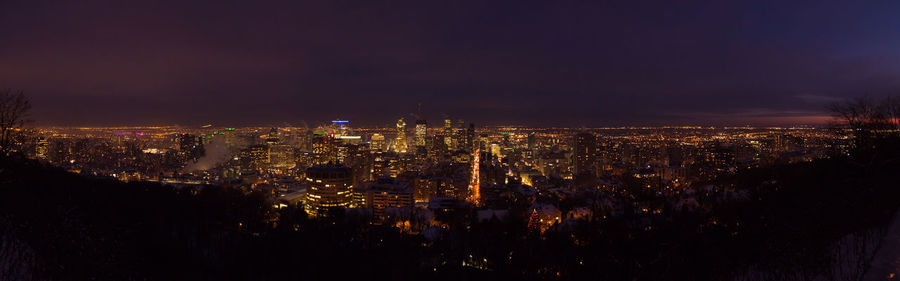 High angle view of illuminated city against sky at night