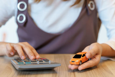 Midsection of woman using smart phone on table