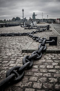 Metal chain on river against sky