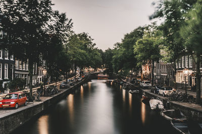 Bridge over canal in city against sky